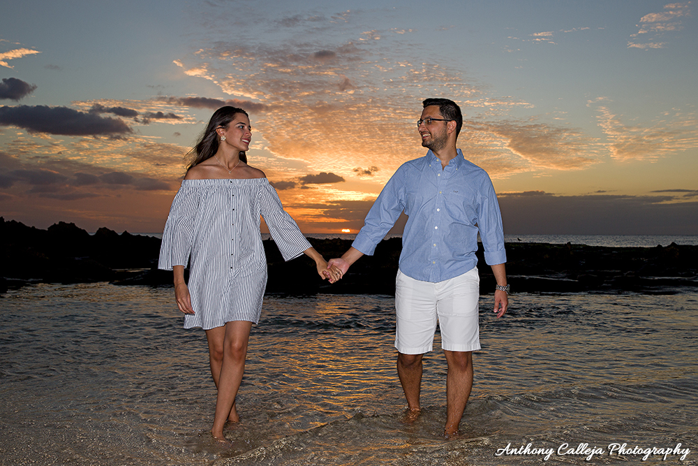 Clothing Ideas - Beach Portrait of a Couple wearing white and blue clothes, honding hand, walking at Sunset at Paradise Cove Beach, Oahu, Hawaii