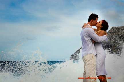 Oahu Hawaii Honeymoon Photography - Couple Kissing Romantically with crashing waves at Makapuu, Oahu, Hawaii