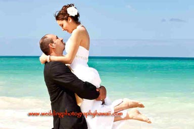 Honolulu Wedding Photographers - Groom lifting bride waimanalo beach