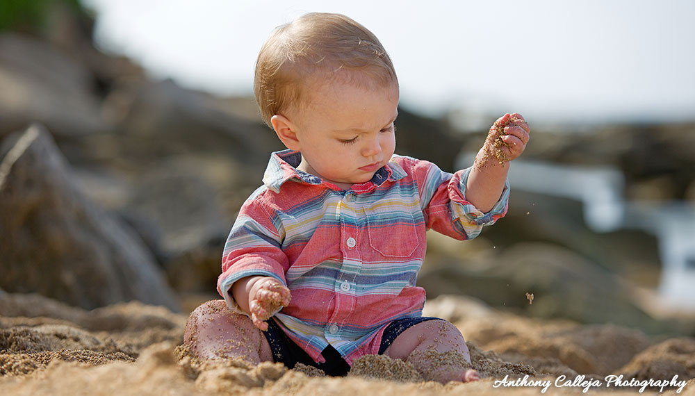 Little Boy todler sitting and playing in the sand at Paradise Cobe Beach
